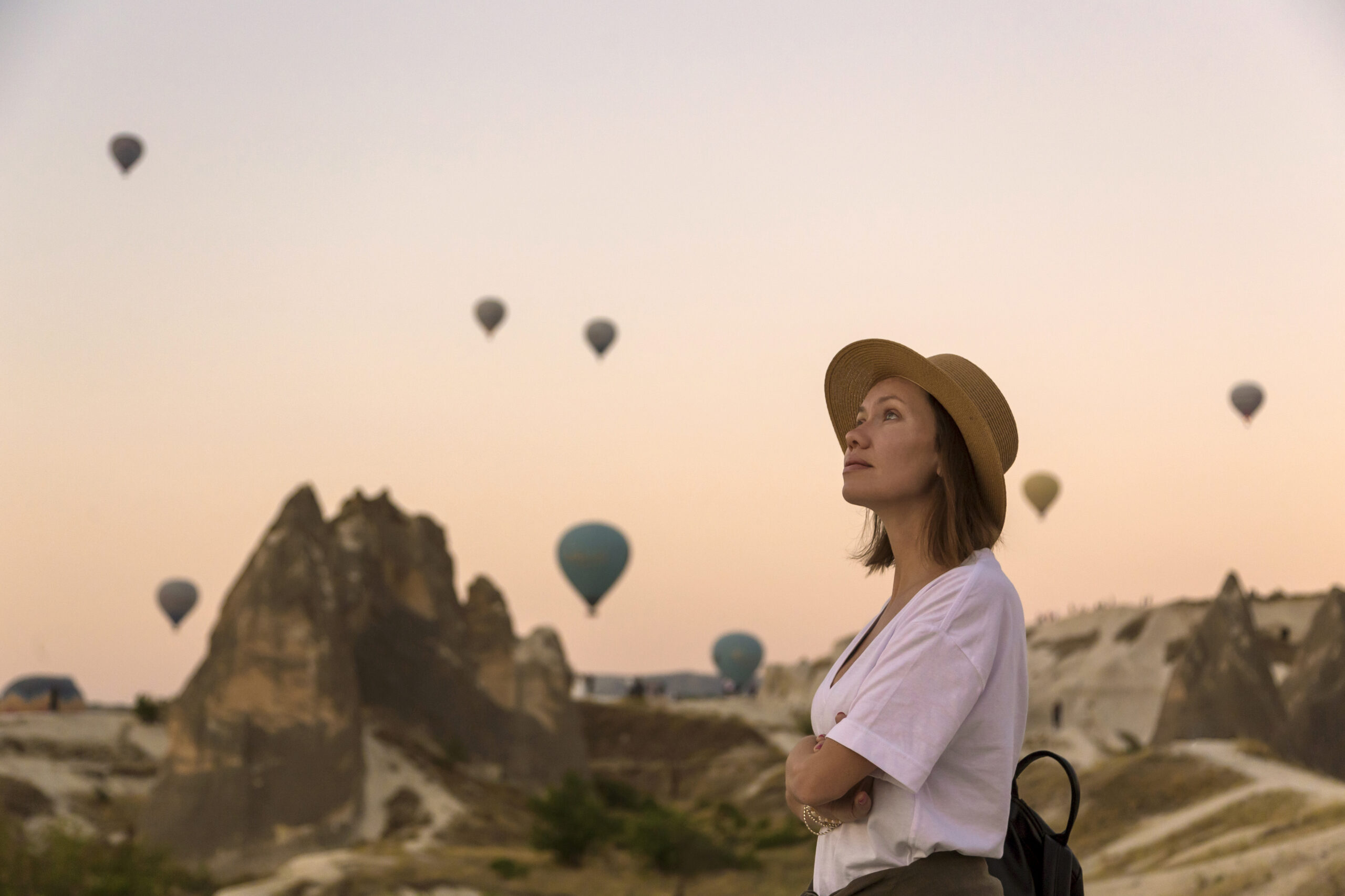 Young woman and hot air ballons, Goreme, Cappadocia, Turkey